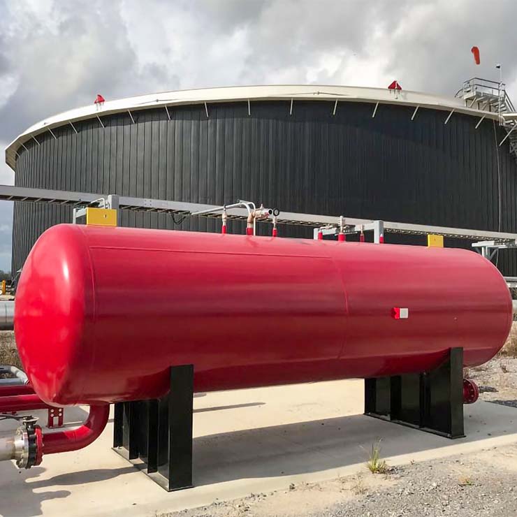 A pressure vessel is filled with Protect-o-Burn's Self Expanding Fire Fighting Foam and is standing ready to protect a massive storage tank filled with oil