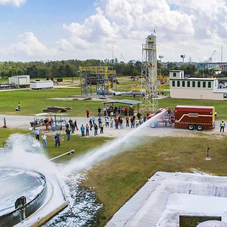 A pressure vessel is filled with Protect-o-Burn's Self Expanding Fire Fighting Foam and is standing ready to protect a massive storage tank filled with oil